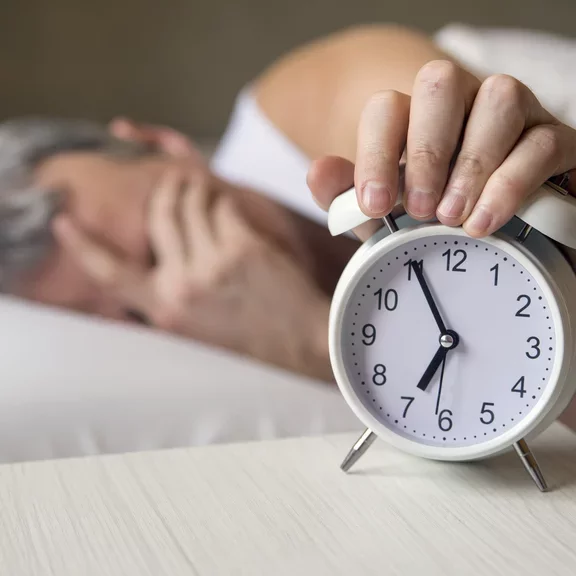 Male adult shutting down alarm clock