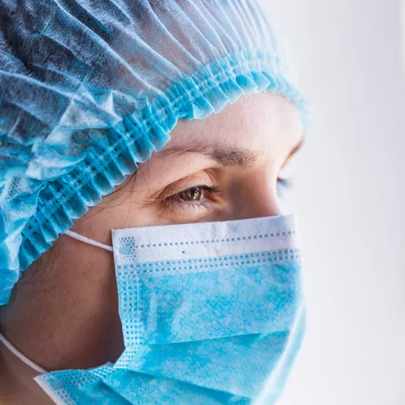 Portrait of a doctor woman in a medical mask and a protective cap